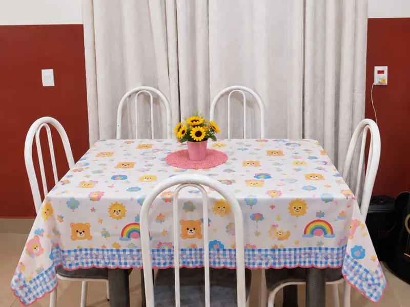Mesa das refeições com toalha de ursinhos e arco-íris