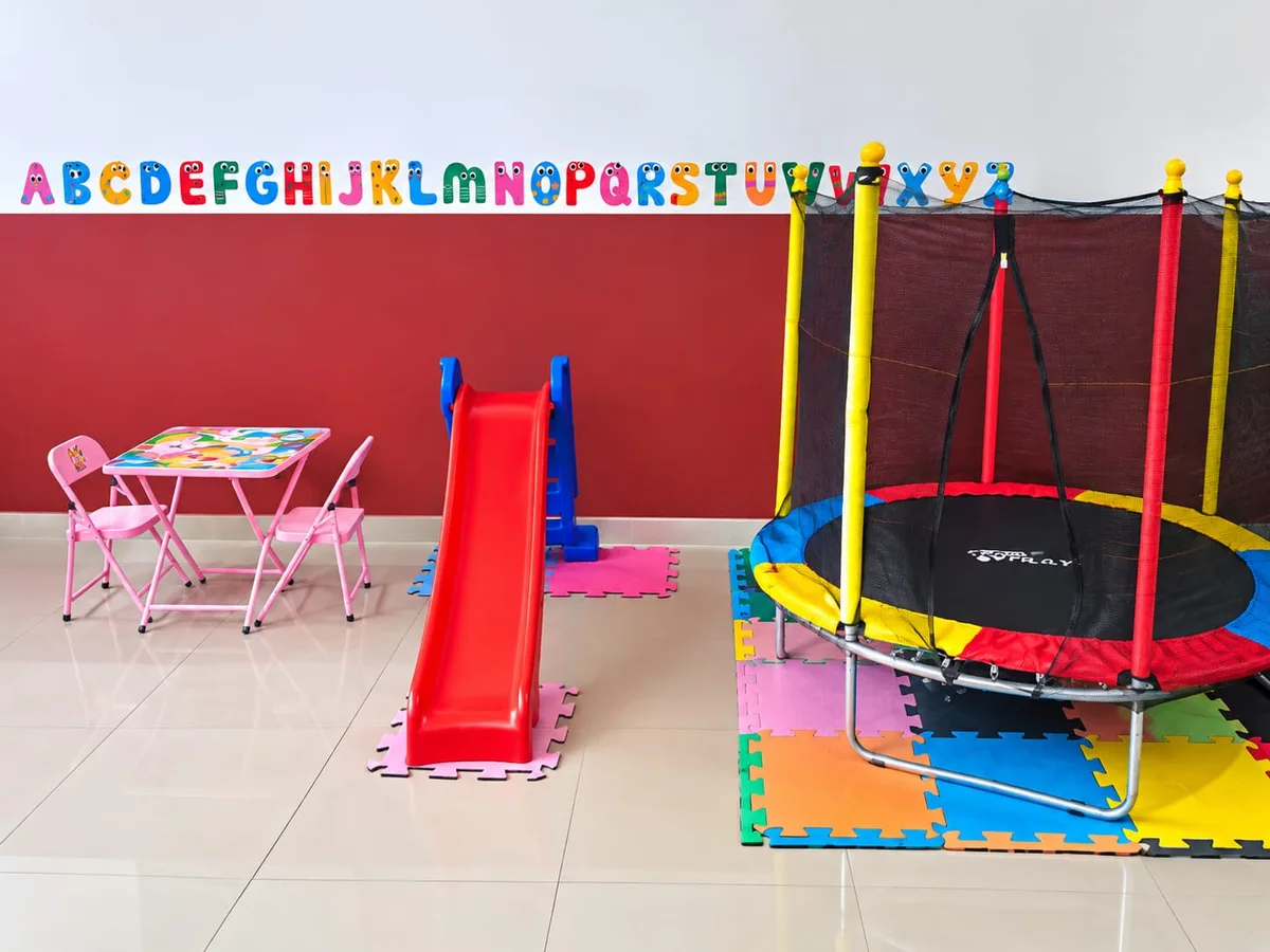 Sala de brincar do Hotelzinho com escorregador, pula-pula e mesinha